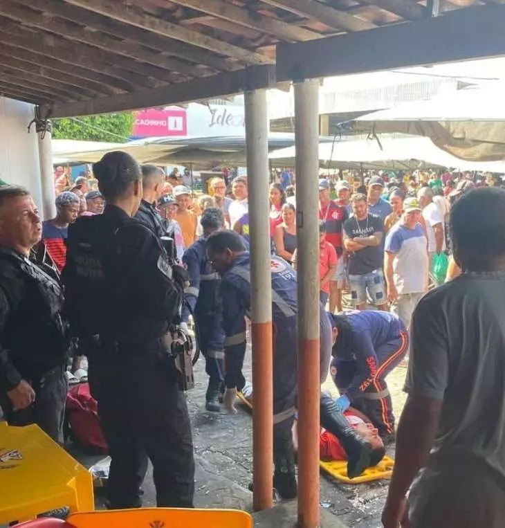 Baleado, homem corre entre barracas de feira para pedir ajuda